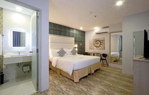 a bedroom with a large bed and a bathroom at Amethyst Boutique Hotel Cebu powered by Cocotel in Cebu City