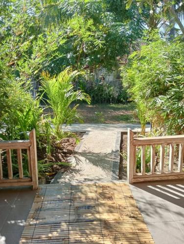 two wooden benches sitting next to a walkway at MoonBag Bungalows in Gili Air
