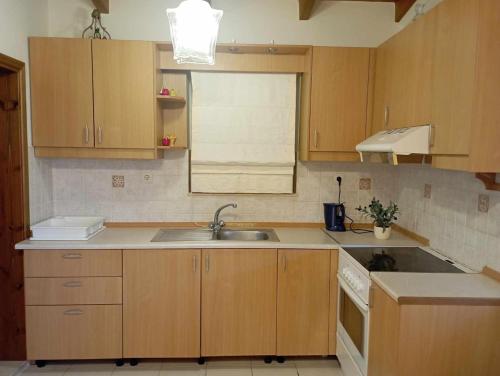 a kitchen with wooden cabinets and a sink at Katavias House in Kattavía