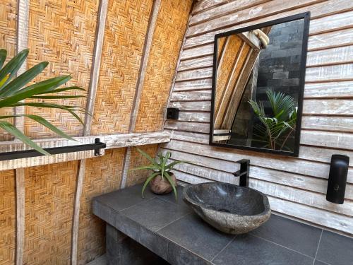 a bathroom with a sink and a mirror on a wall at MoonBag Bungalows in Gili Air