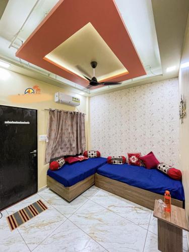 a room with two beds and a flat screen tv at JAI SWAMiNARAYAN DELUX HOMESTAY in Garudeshwar