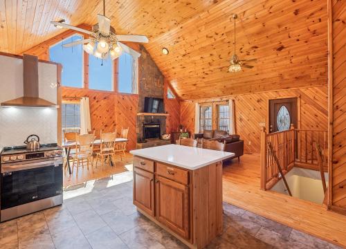 a kitchen and living room in a log cabin at Maggie Valley Cabin with Beautiful Mountain Views, HotTub, Pet Friendly, GameRoom, FirePlace in Maggie Valley
