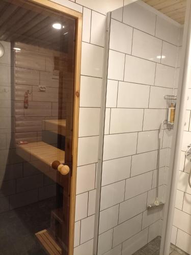 a shower with a glass door in a bathroom at Apartment by the park in Imatra