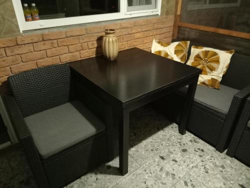 a black table with two chairs and a vase on it at Apartment by the park in Imatra
