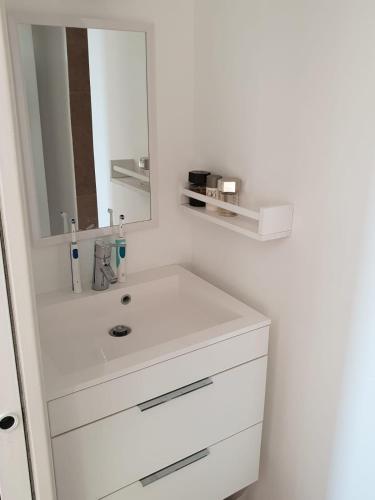 une salle de bain blanche avec un lavabo et un miroir dans l'établissement Villa Ventoux - Luxe in Provence met zwembad 8p, à Malaucène