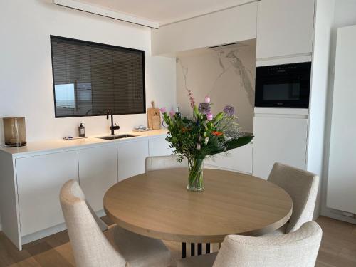 a vase of flowers on a wooden table in a kitchen at Royal Knokke in Knokke-Heist