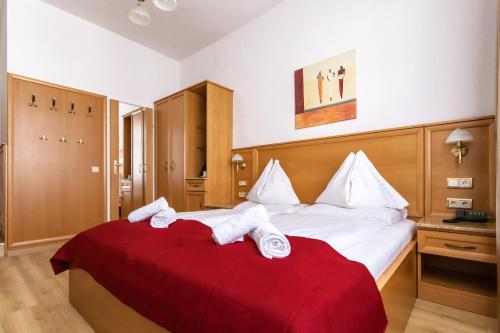 a bedroom with a large bed with towels on it at Hotel Corvinus Vienna in Vienna