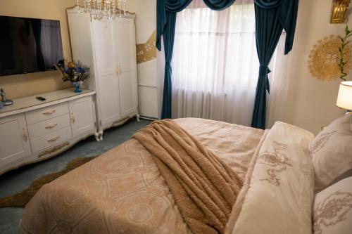 a bedroom with a bed and a dresser and a window at Aparthotel AA in Sarajevo
