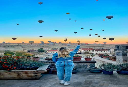 a woman is flying kites in the sky at Seki Cave Suites in Goreme