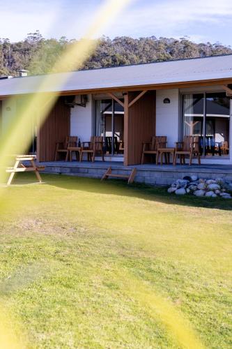 a house with a porch with chairs on it at Beachfront Bicheno in Bicheno
