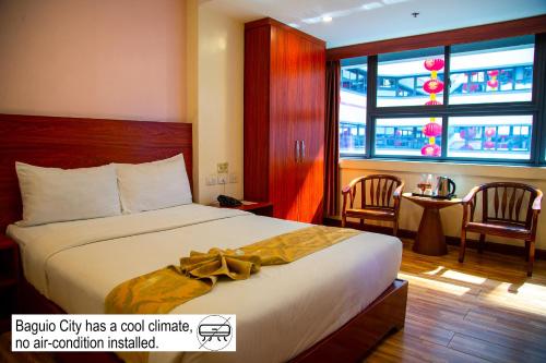 a hotel room with a bed and a large window at 456 Hotel in Baguio