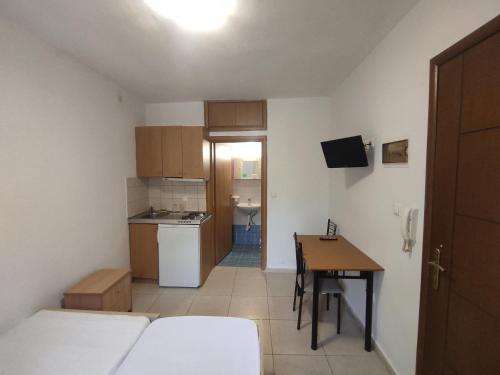 a small room with a kitchen and a table in it at Studios Kapsalas Thessaloniki in Thessaloniki