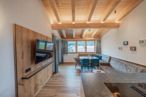 a living room with a table and a tv at Ferienwohnungen Karlingerhof am See in Achenkirch