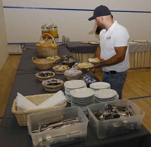 a man is standing in front of a table with food at Camping Sportzentrum Zeltweg - a silent alternative in Zeltweg