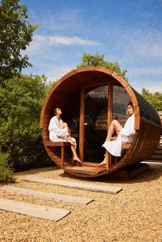a couple of people sitting in a circular wooden pod at Ultimate Provence Hotel & Spa in La Garde-Freinet