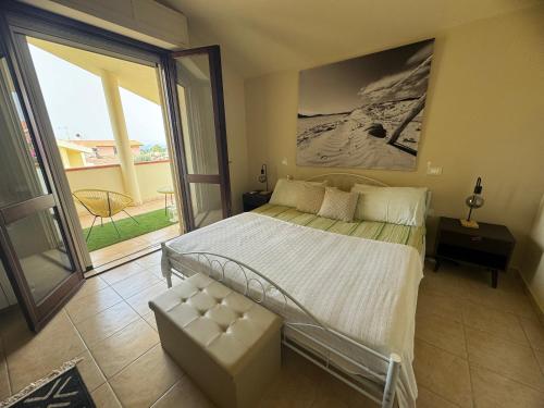 una camera da letto con un letto e una grande finestra di Villa Oliva in Quartu Sant Elena, Capitana, with big Garden and Sea view! a Capitana