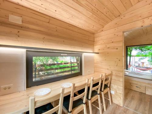 a dining room in a log cabin with a large window at Danube Microhouse in Divici