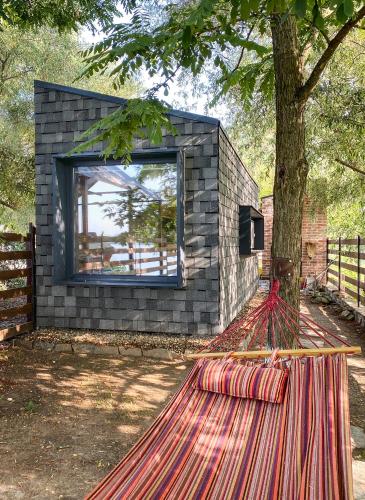 a building with a tree in front of it at Danube Microhouse in Divici