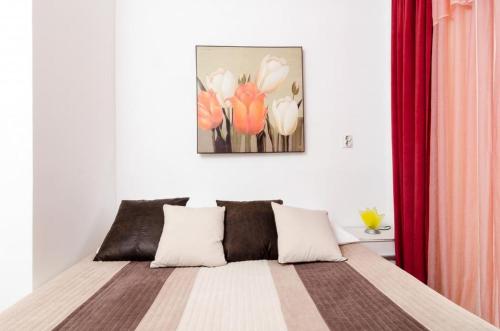 Una cama en una habitación con un cuadro en la pared. en Apartment Nina, en Dubrovnik