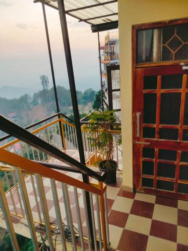 a view from the balcony of a house with a red door at Thakur Apartment in Shimla