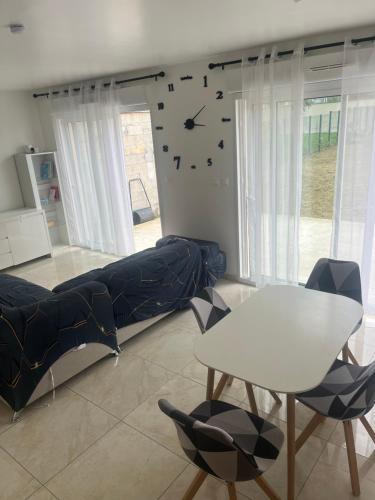 un salon avec un canapé et une horloge au mur dans l'établissement Maison familiale dans un quartier calme, à Villecresnes