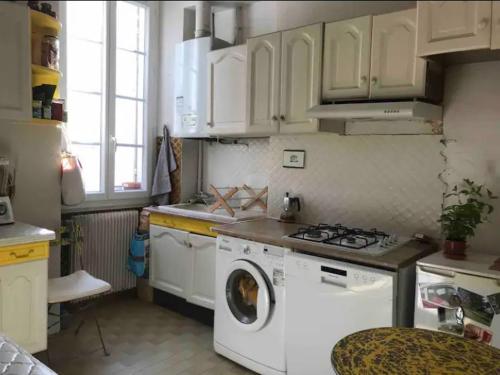une cuisine avec une cuisinière et une machine à laver dans l'établissement Bel appartement avec vu mer, à Marseille