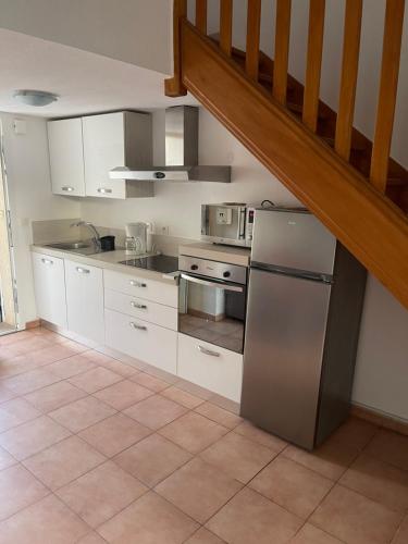 een keuken met witte kasten en een roestvrijstalen koelkast bij A casa di Leia in Borgo