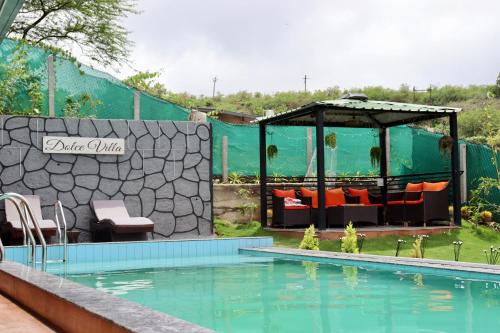 a swimming pool with a gazebo next to a house at Dolce Villa IGATPURI in Igatpuri