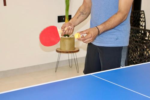 a man is playing a game of table tennis at Dolce Villa IGATPURI in Igatpuri