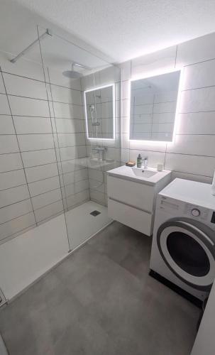une salle de bain blanche avec une machine à laver et un lavabo dans l'établissement Collioure vue imprenable T3 Garage privé, à Collioure