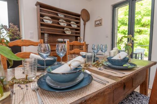 une table en bois avec des assiettes et des verres à vin dessus dans l'établissement L'appartement de Marie - Appt avec terrasse, à Chalon-sur-Saône