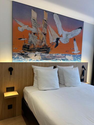 a bedroom with a bed with a painting of a ship at Comic Art Hotel in Ghent