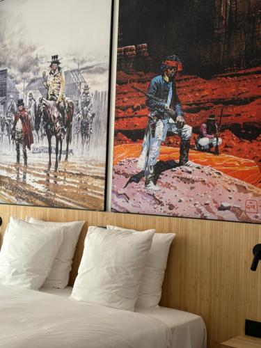 a bedroom with a bed with two posters on the wall at Comic Art Hotel in Ghent