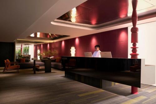 a person sitting at a desk with a laptop at Signature by M Village Thợ Nhuộm in Hanoi