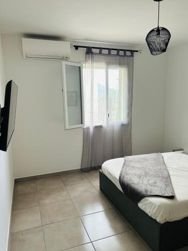 une chambre avec un lit et une fenêtre dans l'établissement Appartement T2 Corte, à Corte