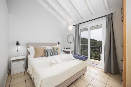 a bedroom with a bed and a large window at Villa Bougainvillea in Vlachopoulátika