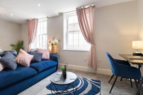 a living room with a blue couch and a table at WhiskAwayStays - Victoria House - Apartment 2 in Worcester