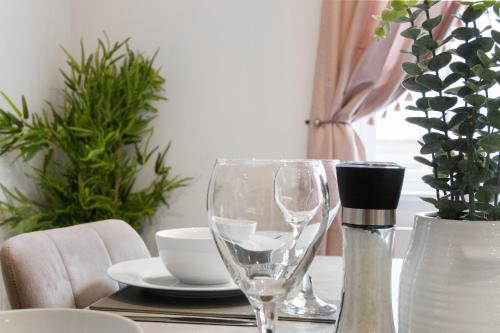 a table with two wine glasses and plates on it at WhiskAwayStays - Victoria House - Apartment 2 in Worcester