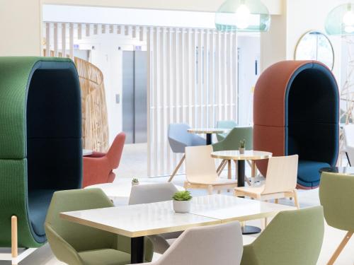 a room with chairs and tables and tablespaces at Novotel Suites Montpellier Antigone in Montpellier