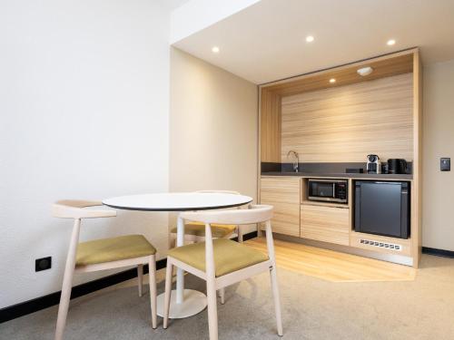 a kitchen with a table and chairs in a room at Novotel Suites Montpellier Antigone in Montpellier