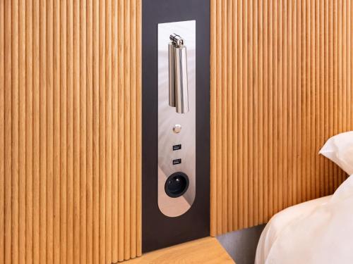 a remote control on a wall next to a bed at Novotel Suites Montpellier Antigone in Montpellier