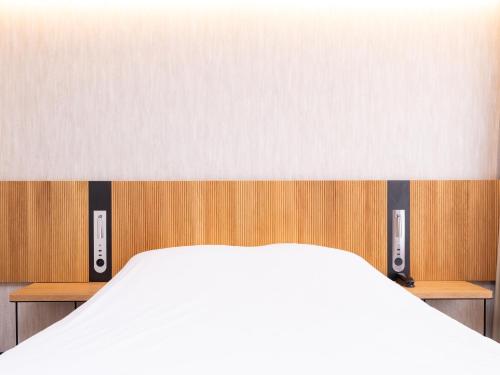 a bedroom with a white bed and wooden walls at Novotel Suites Montpellier Antigone in Montpellier