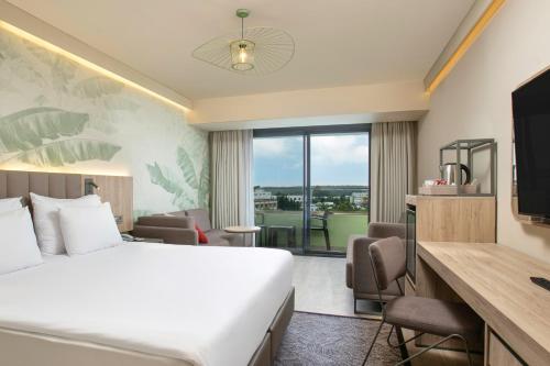 a hotel room with a bed and a desk with a television at Megasaray Resort Side in Side