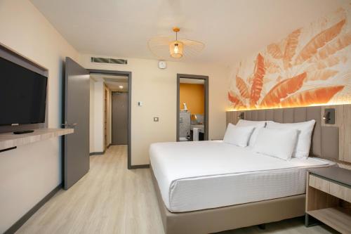 a bedroom with a large bed and a flat screen tv at Megasaray Resort Side in Side