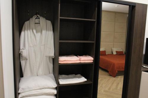 a wardrobe with a robe and towels in a room at Ayhan Hotel in Aktobe