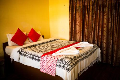 a hotel room with a bed with red pillows at Chitwan Riverside Resort in Sauraha