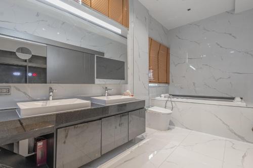 a bathroom with two sinks and a toilet at 芭堤雅最豪华的别墅十卧室十二卫生间 in Nong Prue