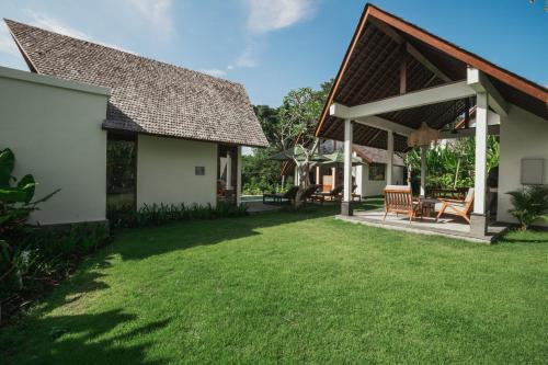 a backyard of a house with a grass yard at Arpana Luxury Private Pool Villas in Jimbaran