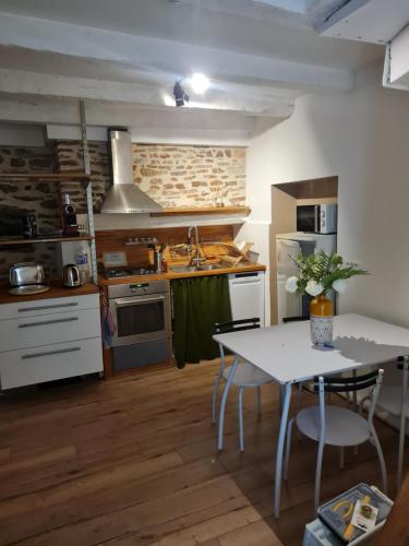 une cuisine avec une table blanche et une table et des chaises dans l'établissement Maison de ville cadurcienne plein centre, à Cahors