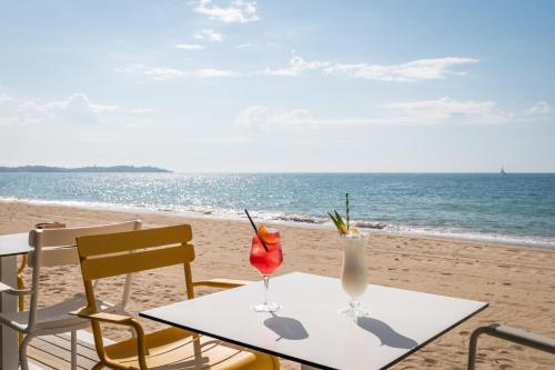 a table with two drinks on the beach at Estival Centurión Playa in Cambrils
